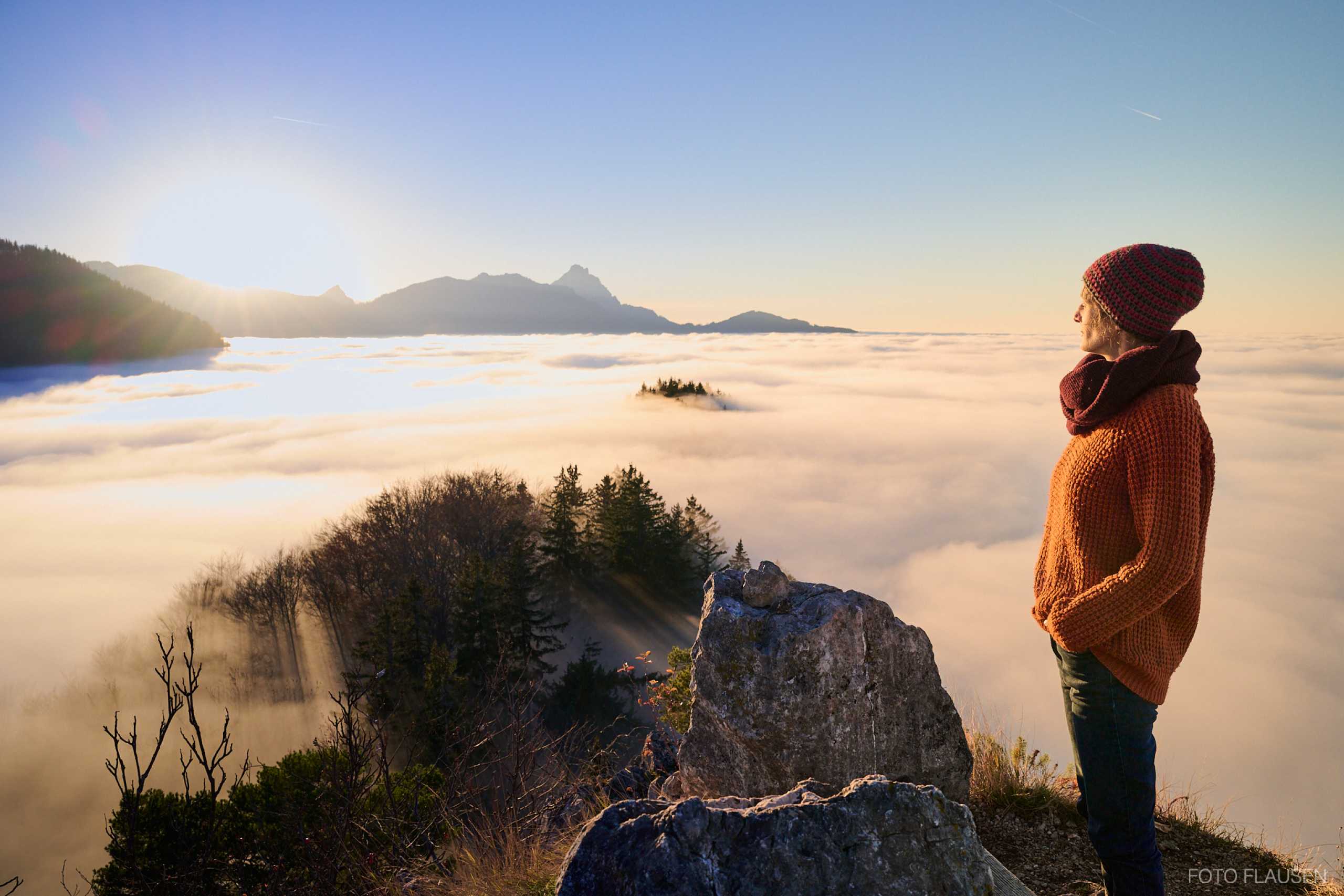 Wanderer Frau im Sonnenuntergang über dem Nebel am Maisenkögerl in Scharnstein Gmunden